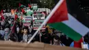 Orang-orang memegang plakat dan melambaikan bendera Palestina dalam sebuah protes pro-Palestina saat Konvensi Nasional Partai Demokrat (DNC) berlangsung di Chicago, Illinois, pada 22 Agustus 2024. (CHRISTIAN MONTERROSA/AFP)