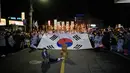 Seorang pemain (kiri depan) ikut serta dalam parade obor api saat orang-orang berkumpul untuk merayakan peringatan Gerakan Kemerdekaan 1 Maret di Cheonan, 90 kilometer selatan Seoul pada 28 Februari 2023. Warga Korea Selatan merayakan hari libur peringatan untuk menandai pemberontakan sipil 1919 melawan Pemerintahan kolonial Jepang dari tahun 1910-1945. (AFP/Anthony Wallace)