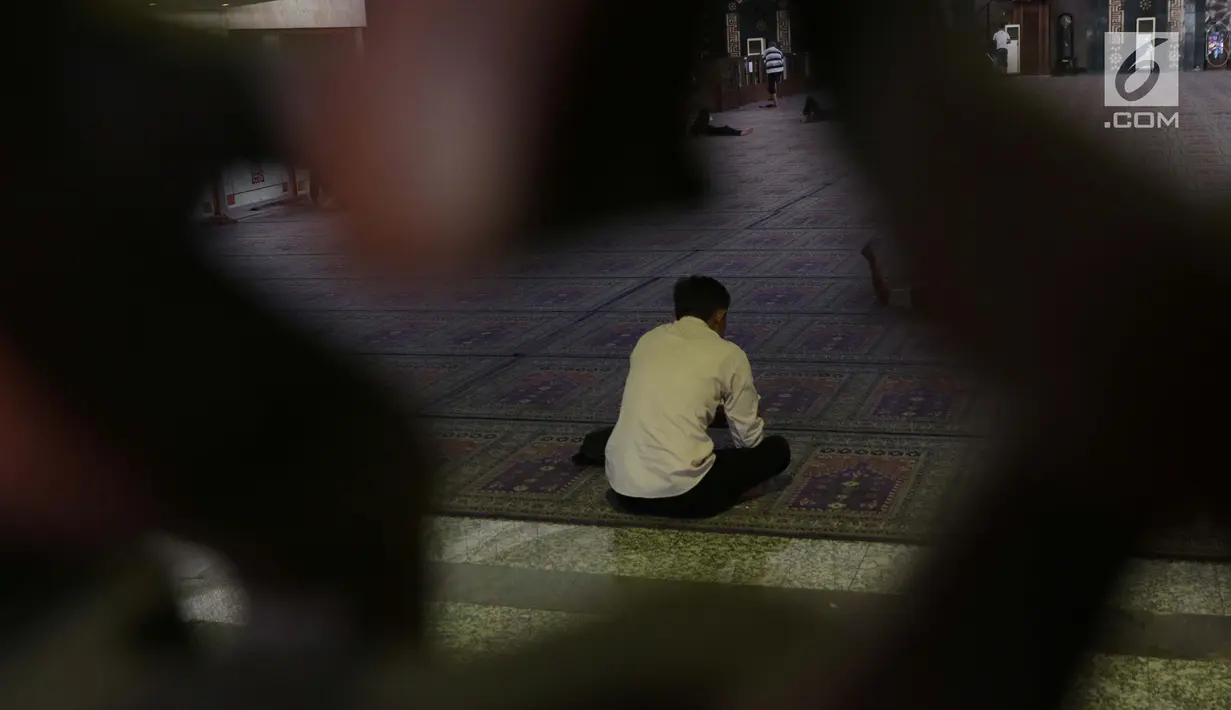 Seorang umat Islam membaca Al-Quran di Masjid At Tin, Jakarta, Selasa (14/7). Bulan suci Ramadan dimanfaatkan umat muslim untuk mendekatkan diri kepada Allah SWT dengan meningkatkan ibadah di masjid. (Liputan6.com/Helmi Fithriansyah)