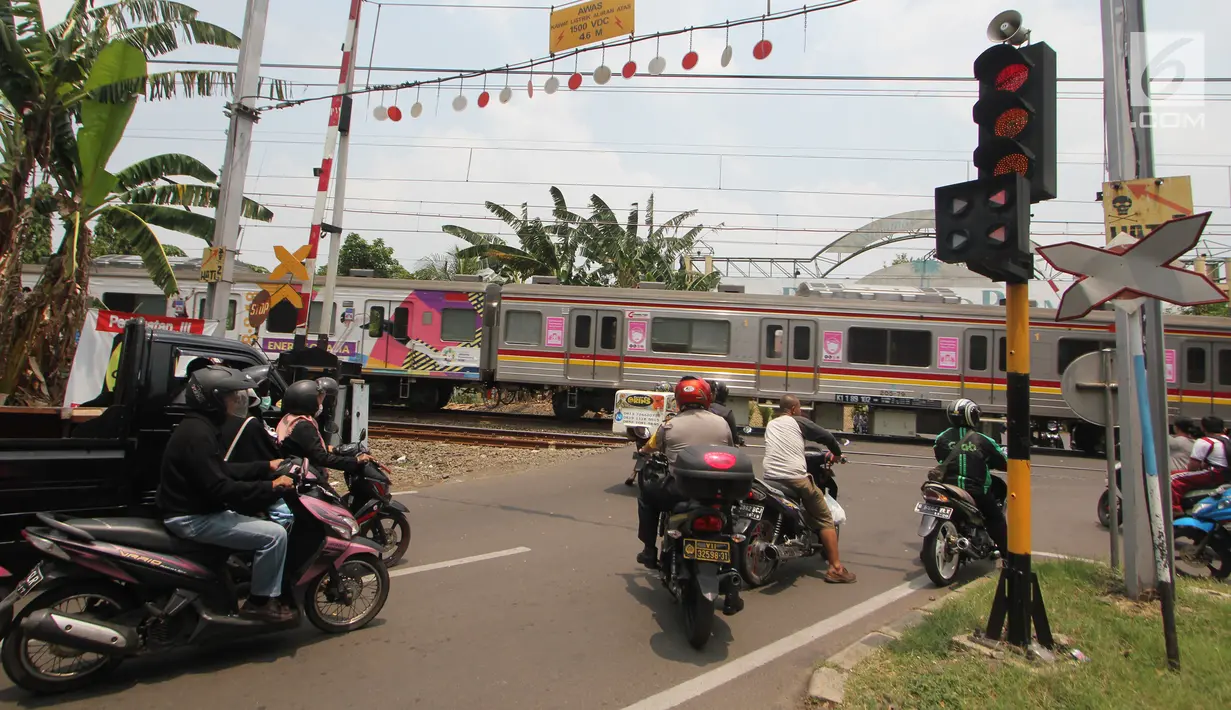 Sejumlah kendaraan berhenti di pintu perlintasan kereta api Bintaro Permai yang tidak berfungsi di Jakarta, Kamis (25/10). Menurut warga sekitar, pintu perlintasan tersebut sudah sejak beberapa bulan terakhir tidak berfungsi. (Liputan6.com/Angga Yuniar)