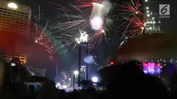 Kembang api menghiasi malam pergantian tahun baru 2019 di kawasan Bundaran HI, Jakarta, Selasa (1/1). Bundaran HI menjadi salah satu pilihan warga menikmati kembang api tahun baru. (Liputan6.com/Angga Yuniar)