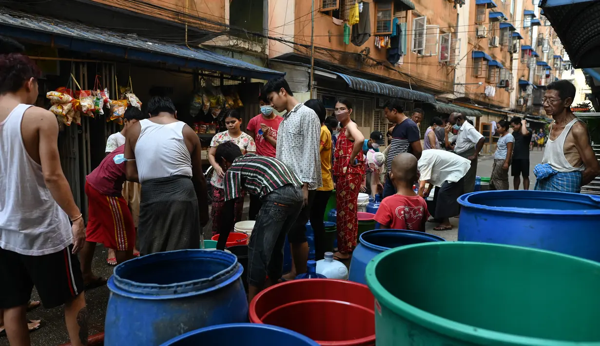 Orang-orang berbaris untuk mengisi wadah dengan air di Yangon, Myanmar (14/3/2022). Ribuan orang menghadapi kekurangan air karena pemadaman listrik di kota tersebut. (AFP/STR)
