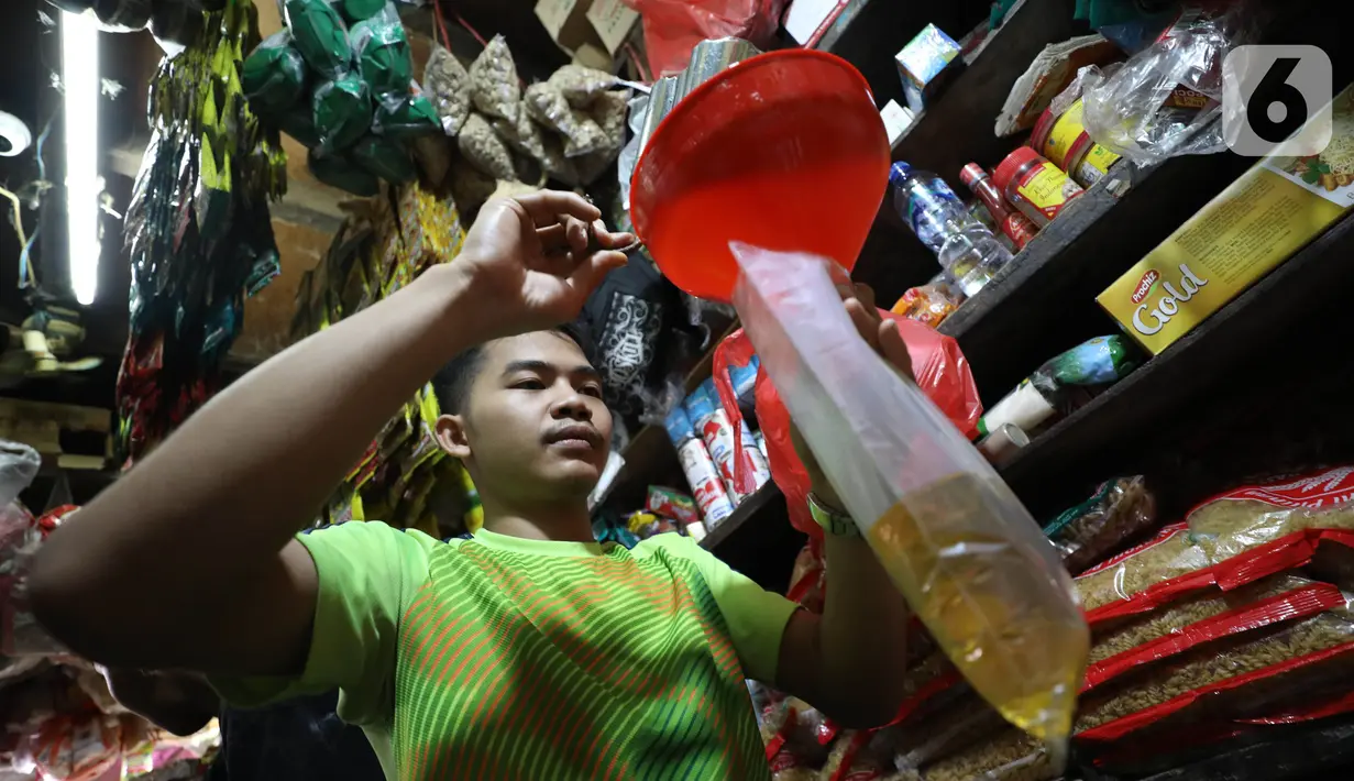 Pedagang tengah mengemas minyak curah di Pasar Kebayoran Lama, Jakarta, Jumat (15/7/2022). Berdasarkan Sistem Pemantauan Pasar Kebutuhan Pokok (SP2KP) Kementerian Perdagangan, harga minyak goreng curah hari ini, Jumat (15/7/2022) berada di level Rp15.200 per liter secara nasional. Harga ini tercatat turun yakni Rp15.236 pada Kamis (14/7/2022). (Liputab6.com/Angga Yuniar)