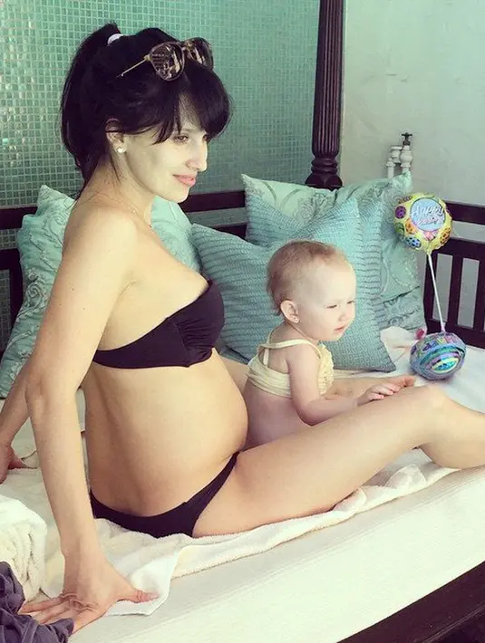 Saat usia putrinya baru delapan bulan, perut Hilaria Baldwin sudah terisi lagi jabang bayi. Hilaria di ranjang bersama dengan putrinya. (Istimewa)