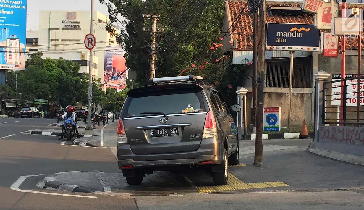 Mobil menutup sebagian badan trotoar di kawasan Jatinegara, Jakarta, Senin (24/9). Kondisi trotoar yang telah diperlebar Pemprov DKI Jakarta kini dipenuhi PKL dan parkir liar sehingga mengganggu kenyamanan pejalan kaki. (Liputan6.com/Immanuel Antonius)