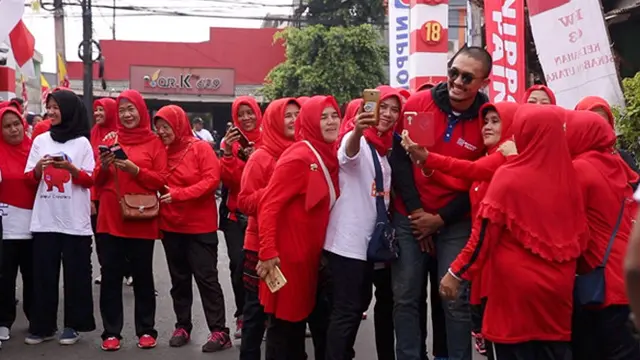 Uus sedang berfoto bersama ibu-ibu berbaju merah.