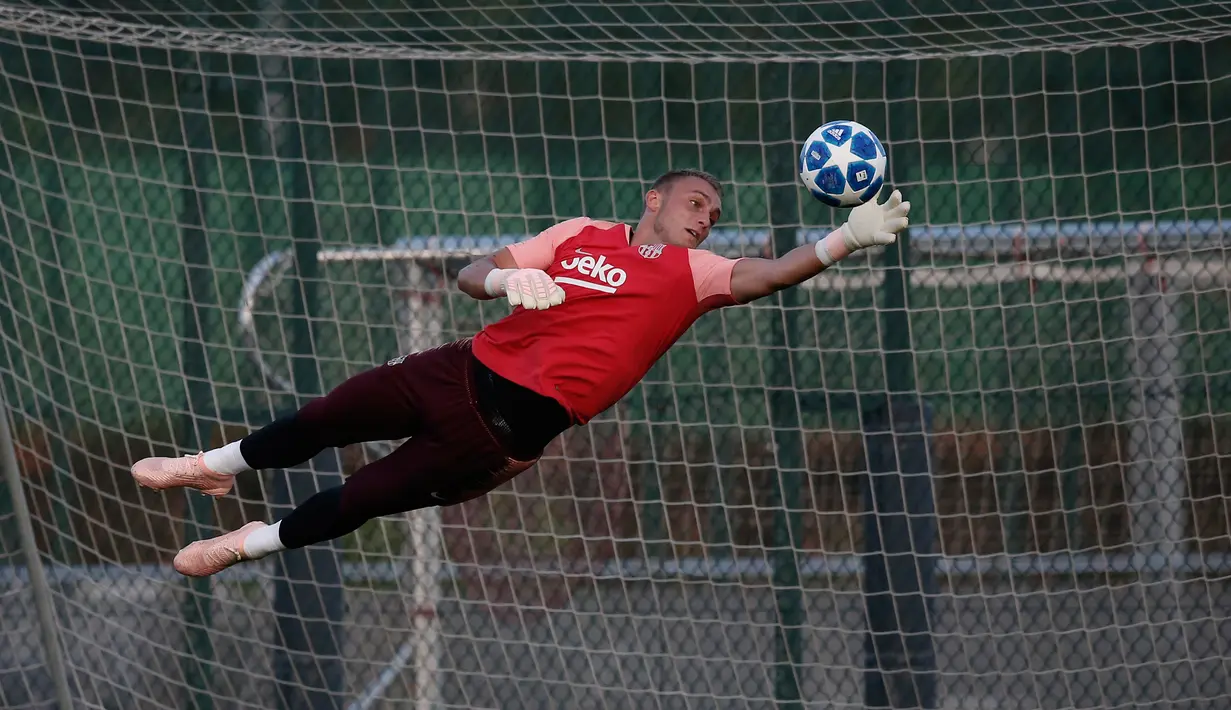 Kiper Barcelona, Marc-Andre ter Stegen berusaha menepis bola saat latihan di Barcelona, Spanyol (17/9). Barcelona akan bertanding melawan PSV Eindhoven pada grup B Liga Champions di Nou Camp. (AP Photo/Manu Fernandez)