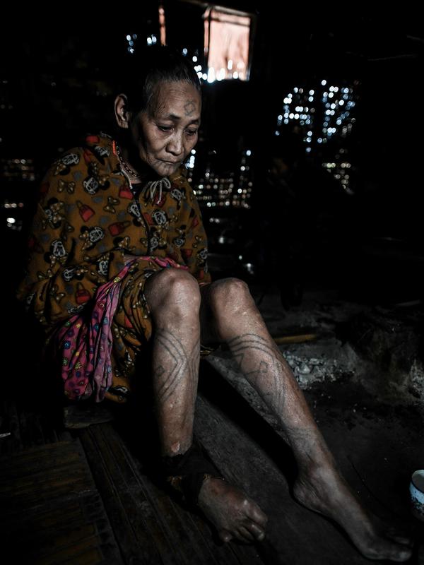 Khamyo Pon Nyun (75), seorang wanita suku Lainong yang bertato beristirahat di rumahnya di Kota Lahel, Sagaing, Myanmar, 6 Februari 2020. Sejumlah suku yang tinggal di zona semi-otonom dekat perbatasan India menjadikan tato sebagai tradisi. (Ye Aung THU/AFP)