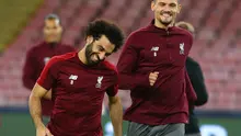 Pemain Liverpool, Dejan Lovren dan Mohamed Salah tertawa selama sesi latihan di stadion San Paolo di Naples, Italia (2/10). Liverpool akan bertanding melawan Napoli pada grup C Liga Champions. (AFP Photo/Carlo Hermann)