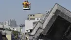 Lee Tsung-tien (42) diangkat dengan menggunakan crane oleh regu penyelamat di apartemen yang ambruk akibat gempa di kota Tainan, Taiwan, Senin (8/2). Dua korban berhasil diselamatkan setelah terperangkap selama lebih dari 50 jam. (AFP PHOTO/Sam Yeh)