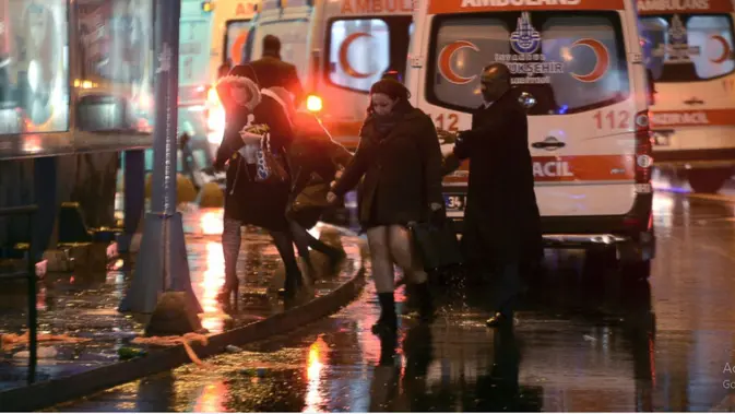 Orang-orang pergi saat petugas medis dan keamanan bekerja di tempat kejadian setelah serangan di klub malam populer Reina di Istanbul, awal 1 Januari 2017. IHA via AP