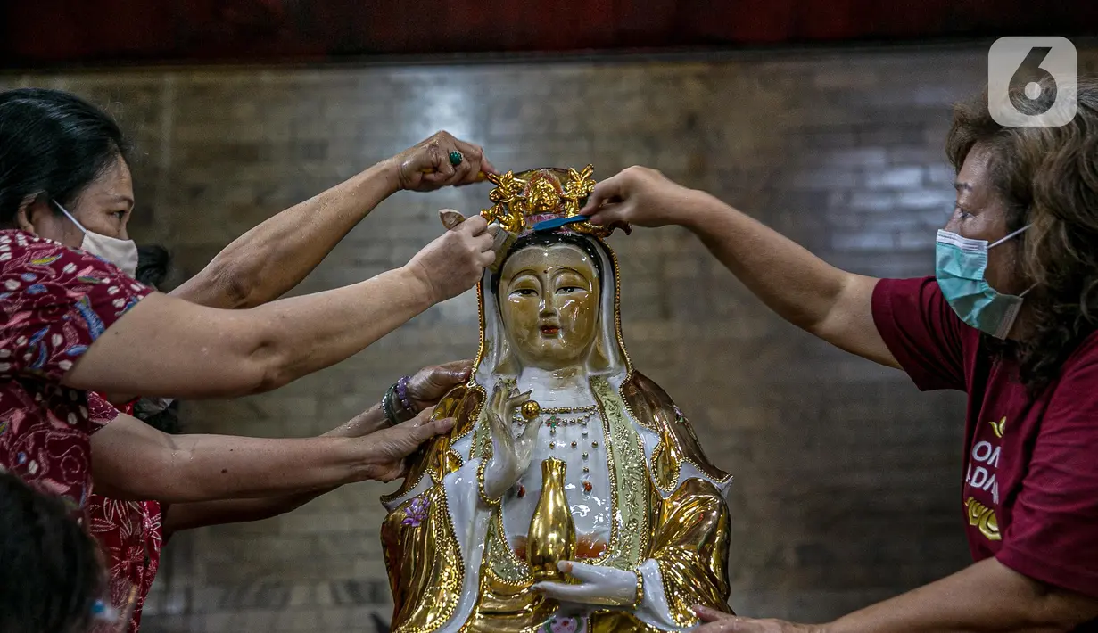 Para jemaat menyikat patung yang ada di Vihara Amurva Bhumi, Jakarta, Kamis (4/2/2021). Ritual mencuci patung dewa serta bersih-bersih ini dilakukan dalam rangka menyambut perayaan Tahun Baru Imlek 2572. (Liputan6.com/Faizal Fanani)
