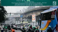 Kendaraan melintas di bawah papan informasi sistem ganjil genap di Jalan S Parman, Jakarta, Rabu (1/8). Pemprov DKI hari ini resmi memberlakukan sistem ganjil genap dengan memberikan sanksi tilang bagi pengendara yang melanggar. (Liputan6.com/Johan Tallo)