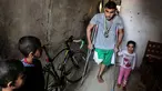 Atlet sepeda asal Palestina, Alaa Al-Daly berjalan menggunakan kruk di rumahnya di Rafah, Jalur Gaza, 19 April 2018. Impian atlet 21 tahun itu untuk berkompetisi di ajang Asian Games seketika pupus karena kaki kanannya diamputasi. (AFP/SAID KHATIB)