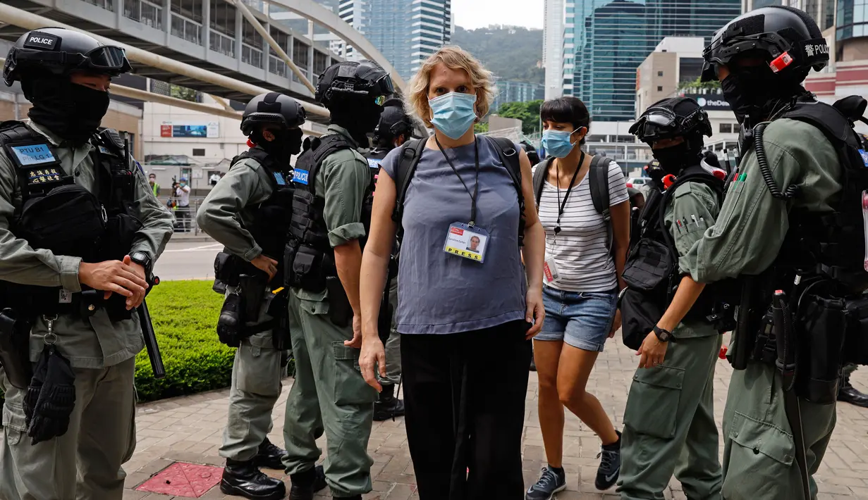 Polisi anti huru hara memeriksa kartu pers wartawan di luar gedung Dewan Legislatif di Hong Kong, Rabu (27/5/2020). Penjagaan ekstra dilakukan menimbang kemungkinan aksi menentang Rancangan Undang-undang (RUU) yang mengkriminalkan penghinaan terhadap lagu kebangsaan China. (AP Photo/Kin Cheung)