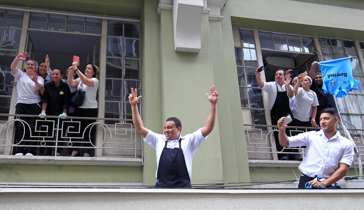 Warga ikut merayakan keberhasilan Gremio meraih juara Copa Libertadores di Porto Alegre, Brasil, Kamis (30/11/2017). Gremio menjadi juara Copa Libertadores setelah mengalahkan Lanus dengan skor agregat 3-1. (AFP/Itamar Aguiar)