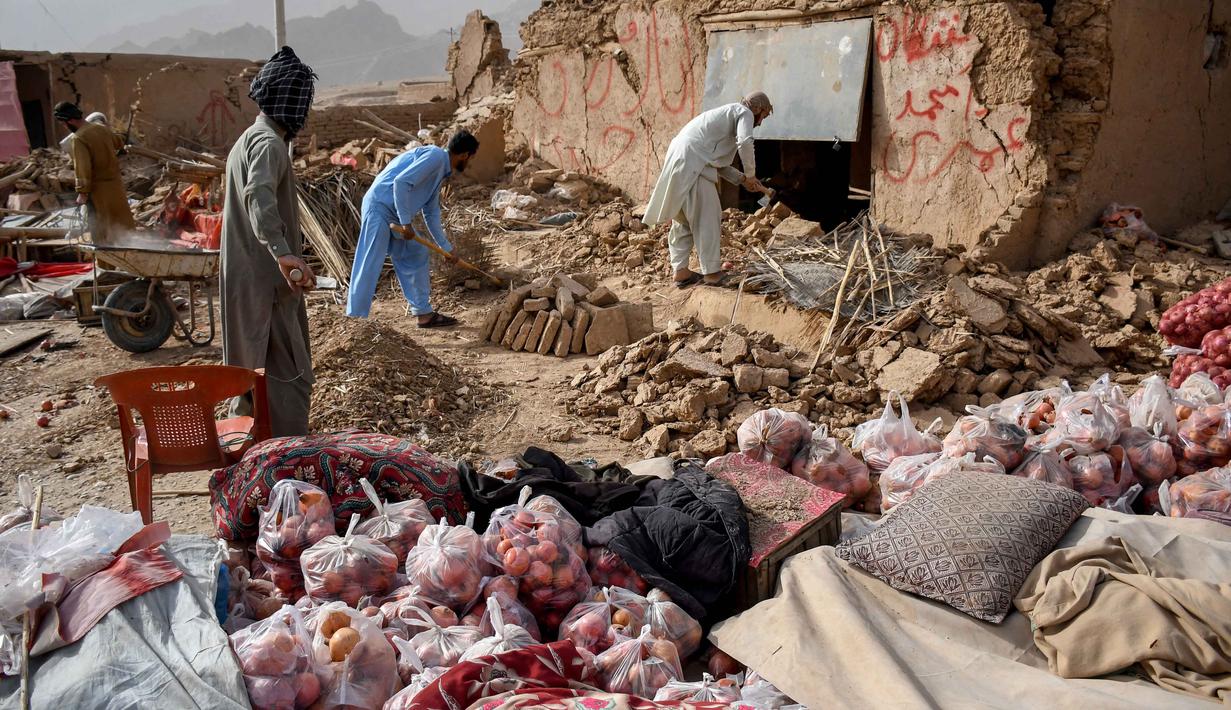 Para pemilik toko di Afghanistan mencari sisa-sisa toko mereka yang rusak di sepanjang jalan raya, menyusul gempa bumi di Tang-e Tashkurgan, distrik Khulm, provinsi Samangan, pada Senin 3 November 2025. Sedikitnya 20 orang dinyatakan tewas dan lebih dari 320 orang terluka setelah gempa bumi mengguncang wilayah utara Afghanistan. (Atif Aryan/AFP)