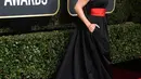 Mandy Moore, datang ke Golden Globes 2018 memakai gaun hitam halter neck. Di bagian pinggang, ia kombinasikan warna merah yang berperan sebagai belt. Cantik banget ya? (Foto: AFP)