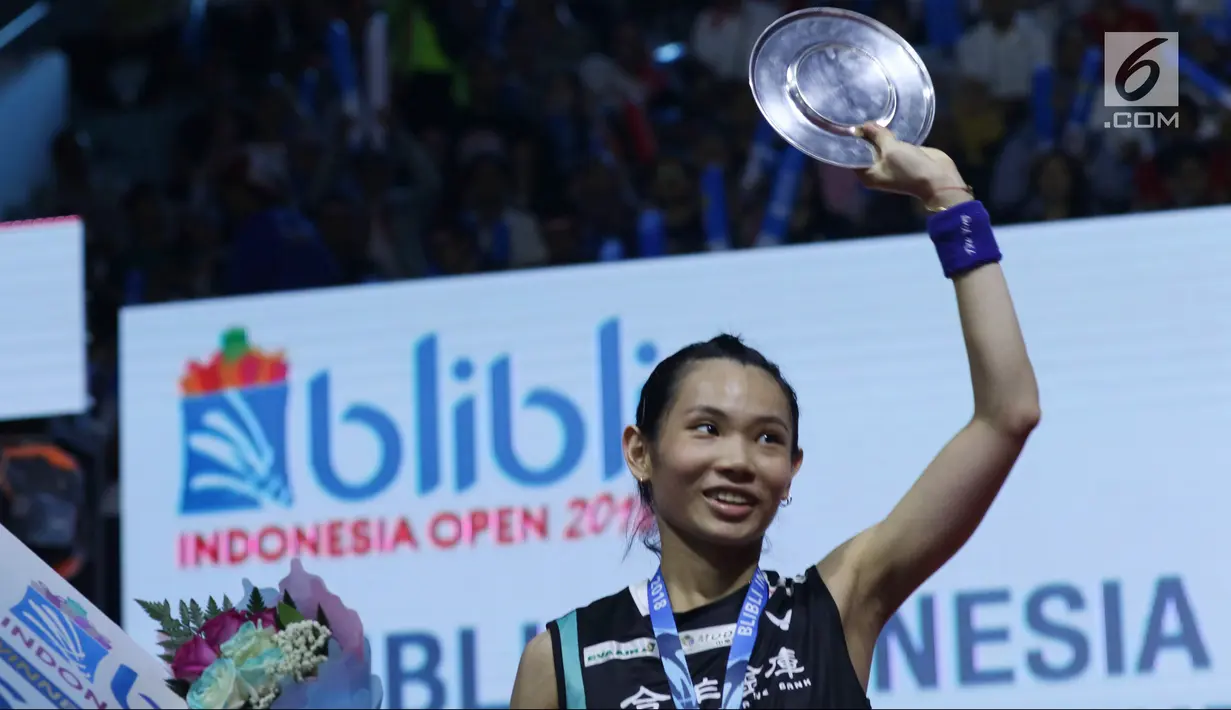 Tunggal putri China Taipei, Tai Tzu Ying mengangkat trophi usai menumbangkan pebulu tangkis China, Chen Yufei saat Final Indonesia Open 2018 di Istora GBK, Jakarta, Minggu (7/7). Tai Tzu Ying menang 21-23 21-15 21-9. (Liputan6.com/Helmi Fithriansyah)