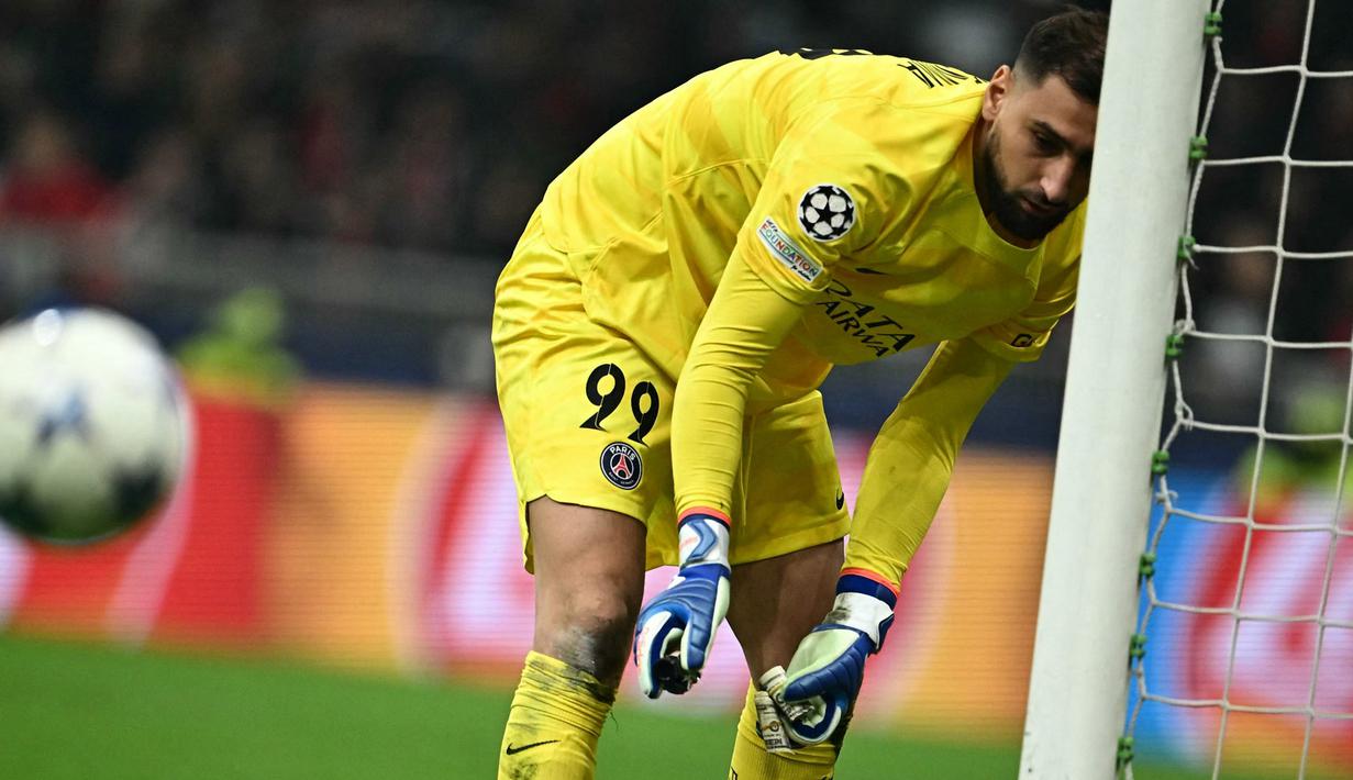 Ekspresi penjaga gawang PSG, Gianluigi Donnarumma, saat memungut uang palsu bergambar dirinya  dalam laga matchday 4 Liga Champions 2023/2024 yang berlangsung di San Siro, Milan, Rabu (8/11/2023) dini hari WIB. (AFP/Gabriel Bouys)