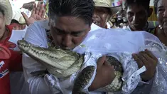 Wali Kota San Pedro Huamelula, Victor Hugo Sosa mencium buaya bernama "La Ni&ntilde;a Princesa" (Gadis Putri) sebelum menikahinya di San Pedro Huamelula, Negara Bagian Oaxaca, Meksiko, Jumat (30/6/2023). (RUSVEL RASGADO/AFP)