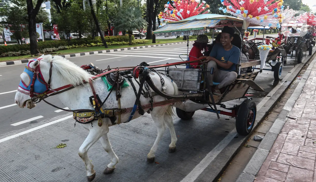 Warga menaiki delman di kawasan IRTI Monas, Jakarta, Jumat (21/8/2020). Jasa sewa delman untuk warga berkeliling kawasan Monas tersebut bertarif Rp50 ribu hingga Rp100 ribu. (Liputan6.com/Johan Tallo)