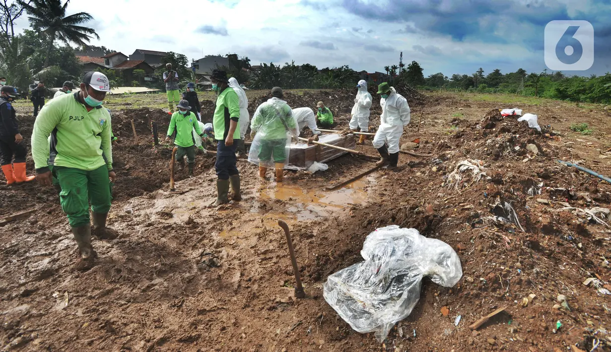 Petugas bersiap melakukan proses pemakaman jenazah dengan protokol COVID-19 di TPU Srengseng Sawah 2, Jakarta, Selasa (9/2/2021). Sudah lebih dari sepekan TPU Srengseng Sawah 2 menerima pemakaman korban COVID-19 dengan jumlah yang dimakamkan sehari maksimal 10 jenazah. (merdeka.com/Arie Basuki)