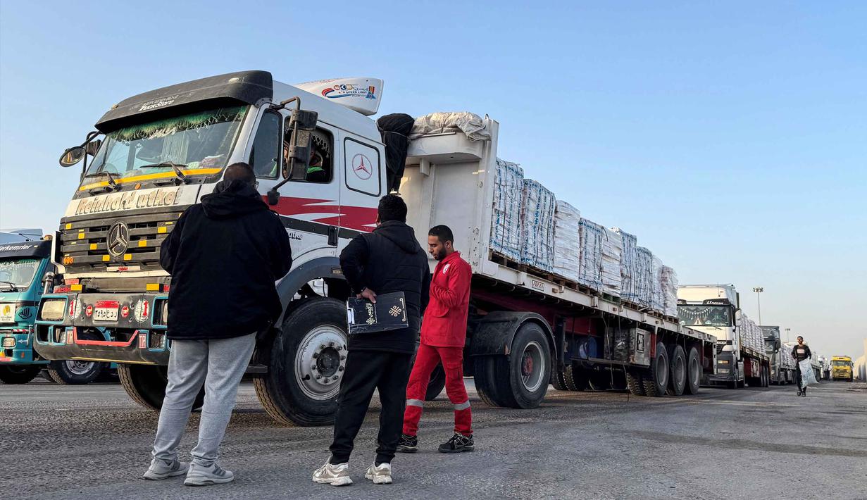 Truk-truk yang mengangkut bantuan kemanusiaan menunggu untuk memasuki perbatasan Rafah di sisi Mesir dengan Jalur Gaza pada 19 Maret 2026. Untuk pertama kalinya sejak Israel dan Amerika Serikat melancarkan serangan terhadap Iran, perbatasan Rafah antara Gaza dan Mesir dibuka kembali. (Amr ADEL/AFP)