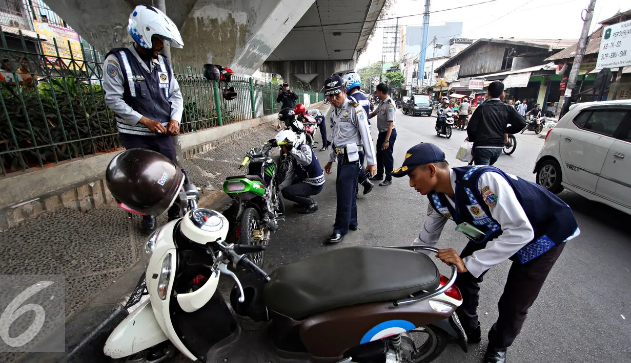 Petugas Dishub mencabut pentil kendaraan roda dua dalam operasi penertiban parkir liar di Pusat, Jumat (23/10/2015). Meskipun informasi penertiban diduga telah bocor, ratusan kendaraan yang parkir liar tetap ditertibkan. (Liputan6.com/Immanuel Antonius)