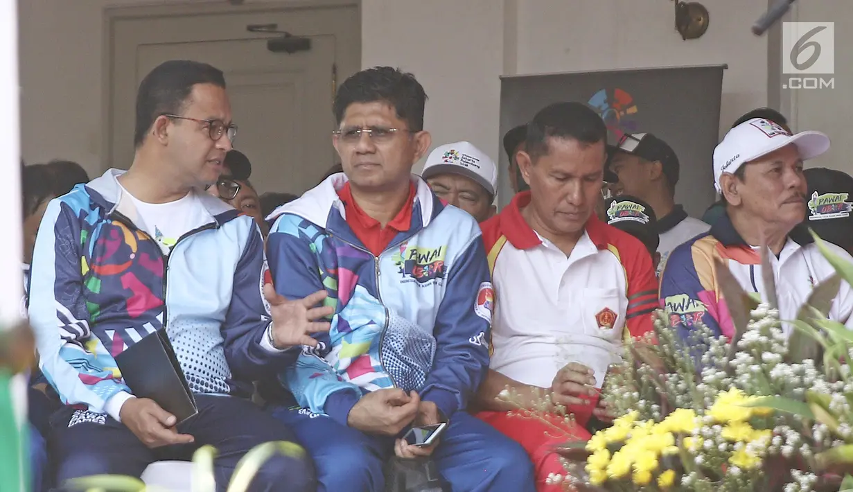 Gubernur DKI Jakarta Anies Baswedan (kiri) berbincang dengan Wakil Ketua KPK Laode Muhammad Syarif (kedua kiri) saat pawai obor Asian Para Games 2018 di Balai Kota DKI Jakarta, Minggu (30/9). (Liputan6.com/Herman Zakahria)