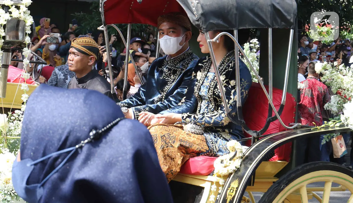 Gibran Rakabuming didampingi sang istri Selvi Ananda saat menaiki kereta dalam mengikuti prosesi kirab Ngunduh Mantu di kawasan Selamet Riyadi, Solo, Jawa Tengah, Minggu (11/12/2022). Kirab ngunduh mantu pernikahan putra bungsu Presiden Joko Widodo, Kaesang Pangarep dan istrinya Erina Gudono yang dimulai dari Loji Gandrung menuju Pura Mangkunegaran tersebut disaksikan ribuan masyarakat Solo dan sekitarnya. (Liputan6.com/Herman Zakharia)