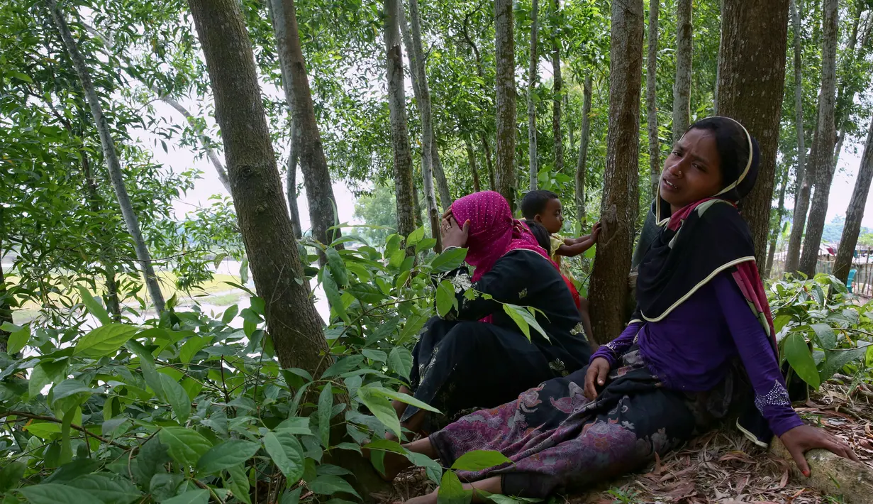 Wanita Rohingya bersama anak-anak berlindung di sebuah hutan sebelum pindah ke sebuah tempat peralihan di perbatasan Bangladesh di perbatasan, Ghumdhum, Bangladesh, (28/8). (AP Photo/Mushfiqul Alam)