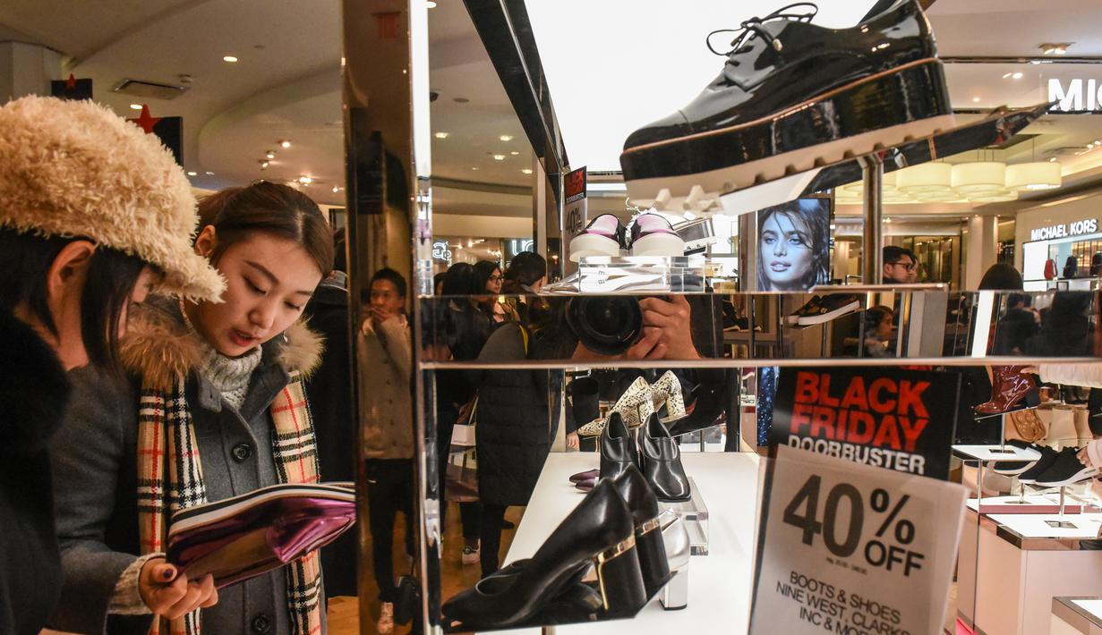 Pembeli memilih sepatu yang dibanderol diskon selama perayaan Black Friday di Macy Herald Square, Manhattan, New York, Kamis (24/11). Black Friday menjadi penanda dimulainya musim belanja bagi warga AS menjelang Natal. (STEPHANIE KEITH/GETTY IMAGES/AFP)