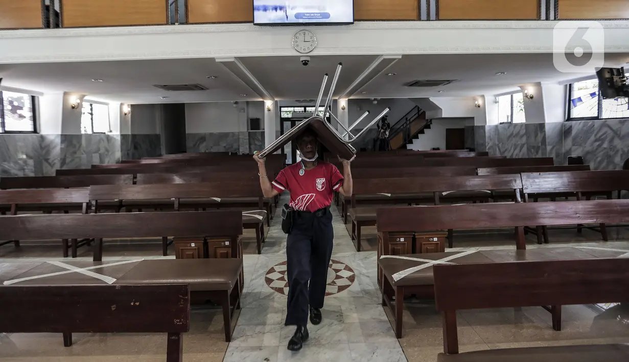 Karyawan memindahkan bangku untuk menyambut kenormalan baru di Gereja Protestan Indonesia Bagian Barat (GPIB) Effatha, Jakarta, Sabtu (4/7/2020). GPIB Effatha menerapkan protokol kesehatan seiring kembali dibukanya gereja tersebut untuk ibadah di tengah pandemi COVID-19. (Liputan6.com/Johan Tallo)