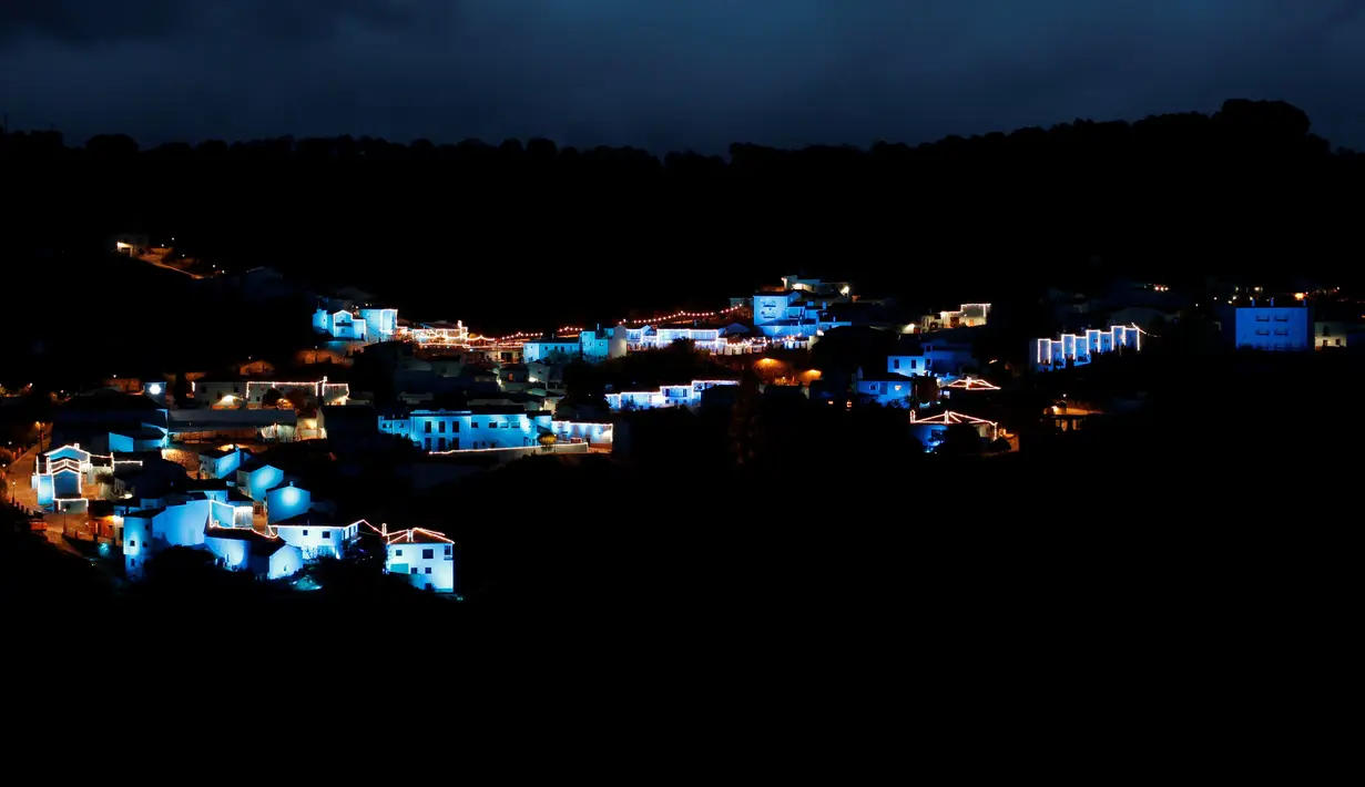 Lampu berwarna biru dinyalakan untuk menandai awal musim Natal di Juzcar, Selatan Spanyol, 2 Desember 2016. Semua bangunan di desa ini sengaja dicat berwarna biru untuk mempromosikan premier film baru "Smurfs: the lost village". (REUTERS/Jon Nazca)