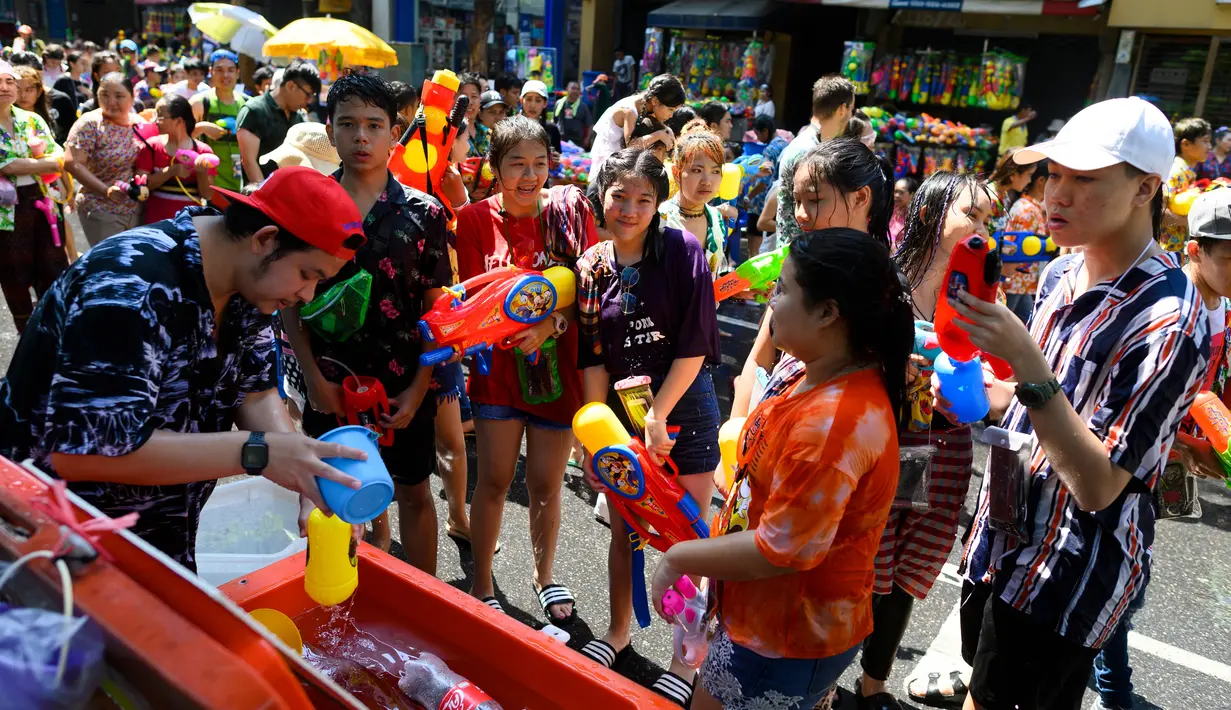 Warga bersuka ria saat mengisi ulang air pada senjata mereka saat merayakan Festival Songkran atau Tahun Baru Thailand di Bangkok, 14 April 2019. Siapa pun bisa bergabung untuk menikmati kemeriahan Songkran. (Permata SAMAD/AFP)
