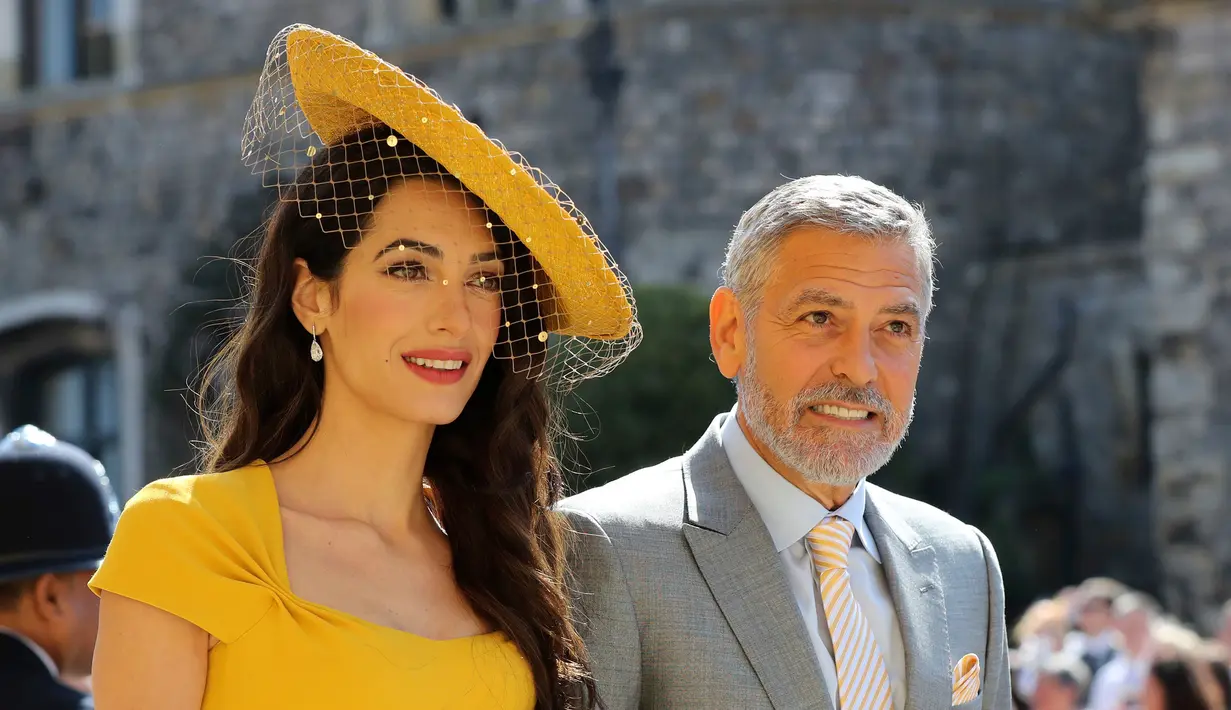 Amal Clooney (kiri) dan George Clooney saat menghadiri upacara pernikahan Pangeran Harry dan Meghan Markle di St. George's Chapel, Windsor Castle, Windsor, dekat London, Inggris, Sabtu (19/5). (Gareth Fuller/pool photo via AP)