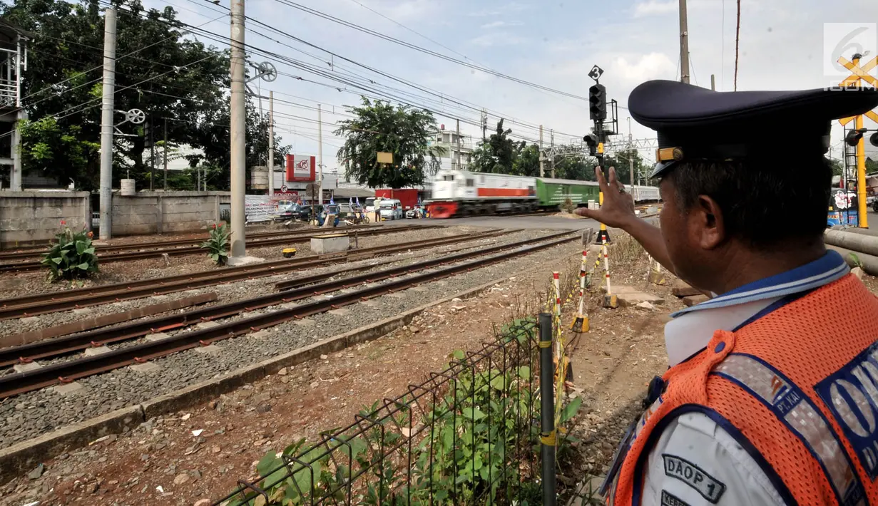 Seorang petugas berjaga di perlintasan kereta api Nomor 52 di Pisangan Lama, Jakarta, Kamis (11/4). Pintu perlintasan ini dan JPL 66 di Jalan Stasiun Cakung, Jakarta Timur, akan ditutup permanen saat diberlakukannya Double Double Track (DDT) lintas Manggarai-Cikarang. (merdeka.com/Iqbal S. Nugroho)