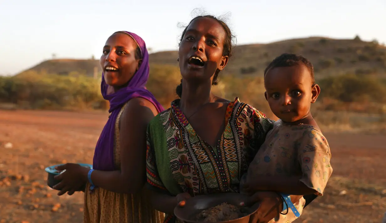 Pengungsi Ethiopia menggendong seorang anak di wilayah Qadarif, Sudan, Rabu (18/11/2020). Pertempuran yang kian meluas di perbatasan Ethiopia dan Sudan mengancam wilayah Tanduk Afrika. (AP Photo/Marwan Ali)