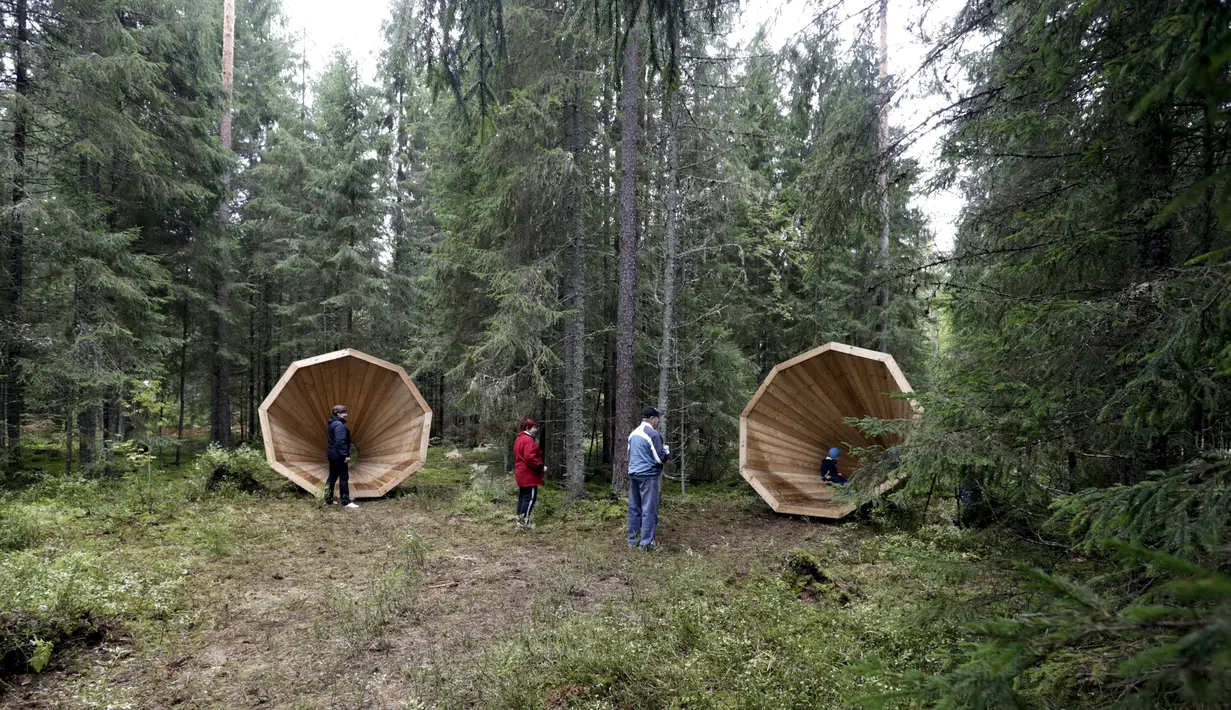Sejumlah orang bermain di dekat megafon raksasa dari kayu buatan sekelompok mahasiswa arsitektur interior di hutan Estonia, 28 September 2015. Megafon ini dibuat untuk mendengarkan suara hutan dan mahluk yang tinggal di dalamnya. (REUTERS/Ints Kalnins)