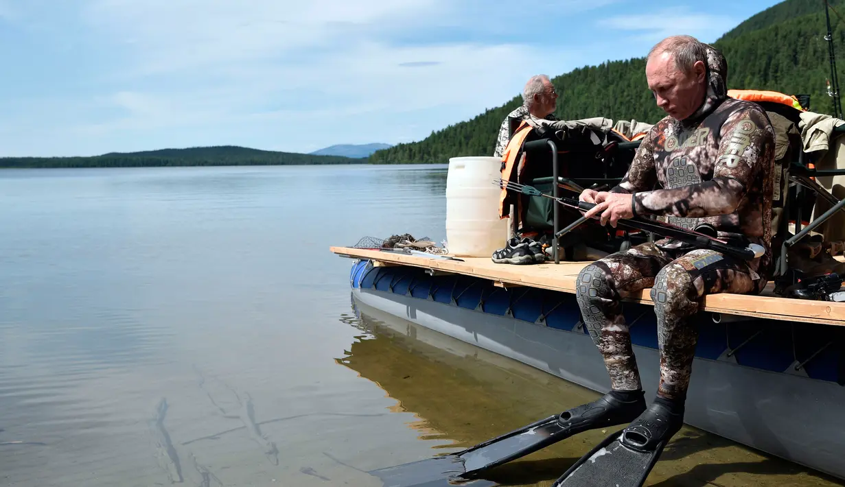 Presiden Rusia Vladimir Putin bersiap untuk berenang saat liburan mini di kawasan Siberia Tyva. Foto dirilis oleh biro pers Kremlin, pada 5 Agustus 2017. (Alexei Nikolsky / Sputnik, Foto Kolam Kremlin via AP)