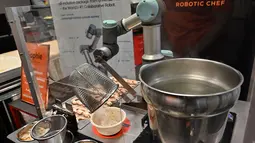 Robot koki bernama Sophie meracik semangkuk laksa saat demonstrasi memasak di Singapura pada 26 Juli 2019. Sebanyak 80 mangkuk laksa dapat disajikan robot koki tersebut dalam waktu satu jam. (Roslan RAHMAN / AFP)
