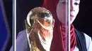 Seorang wanita melihat trofi Piala Dunia FIFA  saat tur Dunia di Ibu Kota Kairo, Mesir (15/3). ). Trofi ini terbuat dari emas murni 18 karat dengan dasar perunggu, setinggi 36,8 sentimeter dan berat 6,1 kilogram. (AFP Photo/Khaled Desouki)