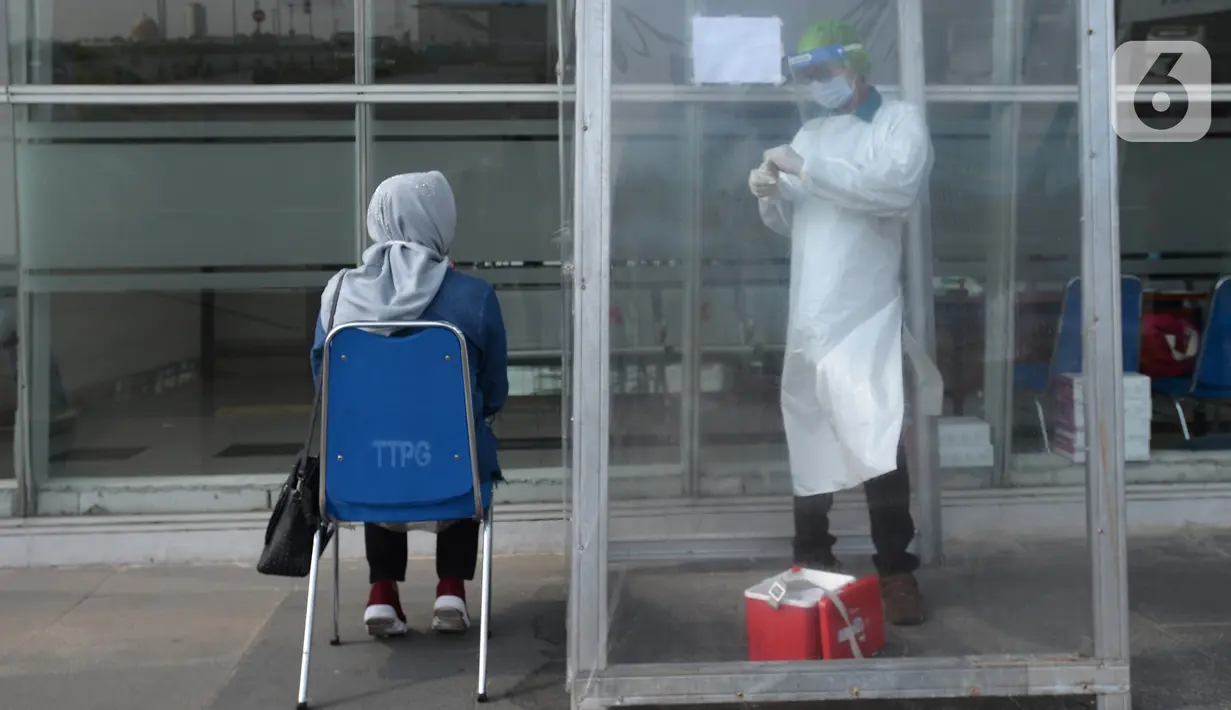 Petugas melakukan swab test antigen kepada pemudik saat arus balik Lebaran di Terminal Pulogebang, Jakarta, Jumat (21/5/2021). Satu minggu setelah Lebaran, pemudik yang tiba di Terminal Pulogebang wajib menjalani tes COVID-19. (merdeka.com/Imam Buhori)