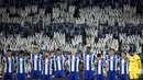 Sejumlah pemain FC Porto mengheningkan cipta dengan latar belakang para penonton yang sedang memegang plakat bergambar nomor punggung dua untuk mengenang kepergian Diogo Costa sebelum laga Liga Portugal 2025/2026 melawan Vitoria Guimaraes SC di Estadio Do Dragao, Porto, Portugal, Senin (11/08/2025) waktu setempat. (AFP/Miguel Riopa)