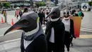 Sejumlah aktivis Greenpeace mengenakan topeng penguin saat menggelar aksi dalam car free day di kawasan Thamrin, Jakarta, Minggu (9/2/2020). Mereka mengajak pemerintah untuk berpartisipasi dalam mewujudkan Perjanjian Laut Internasional (Global Ocean Treaty). (Liputan6.com/Faizal Fanani)