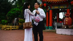 Salah satu pasangan keturunan Tionghoa bersiap mengikuti acara pernikahan massal di Kuil Thean Hou, Kuala Lumpur, Senin (9/9/2019). Upacara pernikahan massal diadakan untuk 99 pasangan pada hari kesembilan bulan kesembilan yang dianggap sebagai tanggal keberuntungan. (Mohd RASFAN / AFP)