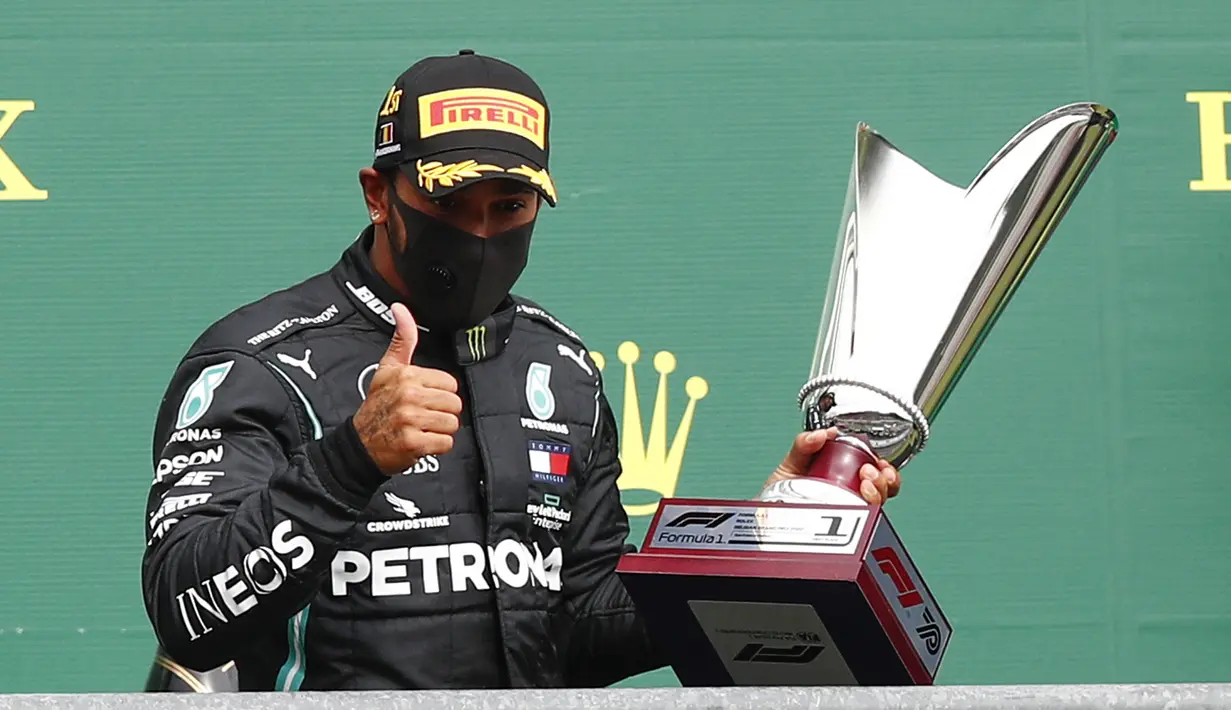 Pembalap Mercedes Lewis Hamilton mengangkat trofi usai menempati posisi pertama Formula 1 Grand Prix di Spa-Francorchamps, Spa, Belgia, Minggu (30/8/2020). Posisi kedua dan ketiga diisi pembalap Mercedes Valtteri Bottas serta pembalap Red Bull Max Verstappen. (Francois Lenoir/Pool Photo via AP)