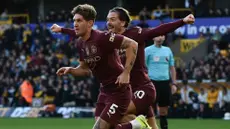 John Stones (kiri) merayakan gol bersama Jack Grealish yang menjadi penentu kemenangan Manchester City atas Wolverhampton 2-1 di laga pekan ke delapan Premier League 2024/2025 di Molineux, Minggu (20/10/2024) malam WIB.