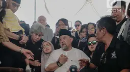 Komedian Indro Warkop menenangkan anaknya saat pemakaman istrinya, Nita Octobijanthy di TPU Tanah Kusir, Jakarta, Rabu (10/10). Nita meninggalkan tiga orang anak. (Liputan6.com/Faizal Fanani)